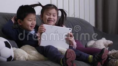 微笑的亚洲小孩在平板电脑上看<strong>搞笑视频</strong>